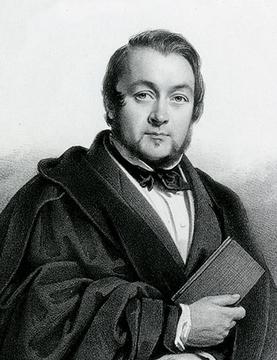 Black and white portrait of a man holding a book, dressed in formal attire.