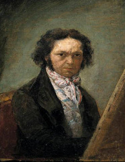 Portrait of a man with a dark coat and light-colored scarf, sitting in front of an easel.
